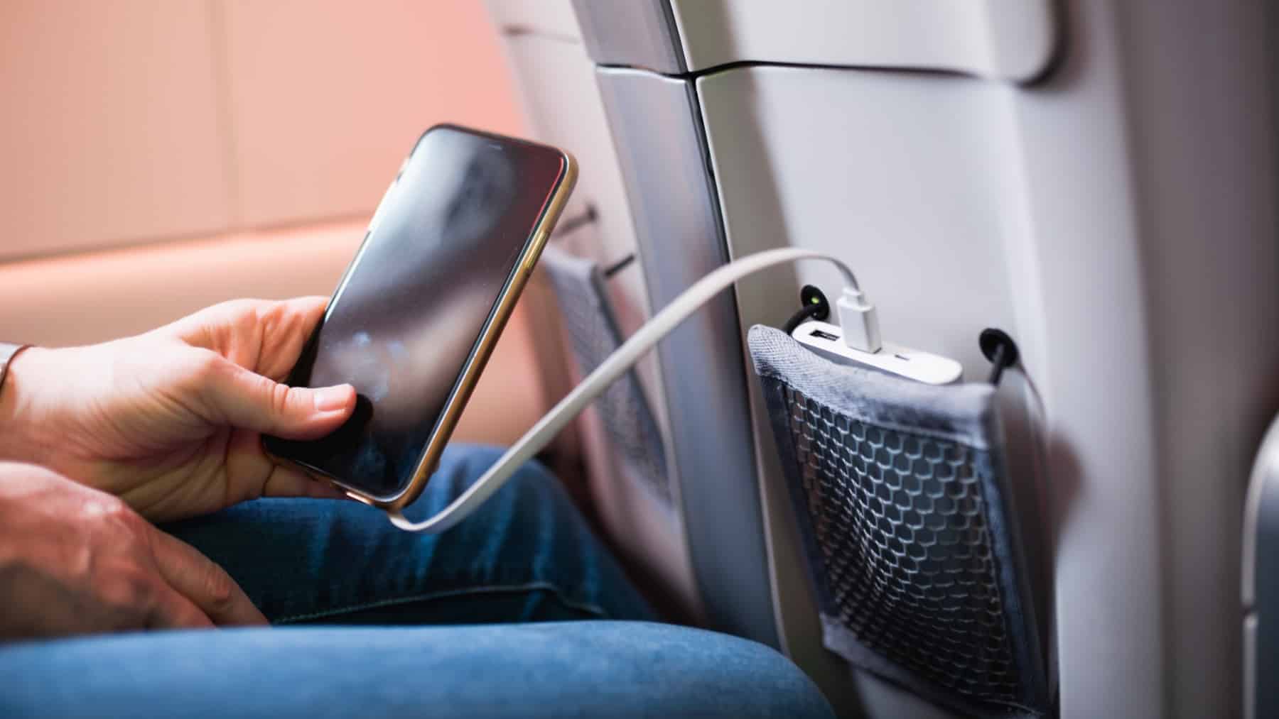 Batterie externe de voyage rechargeant un smartphone en avion